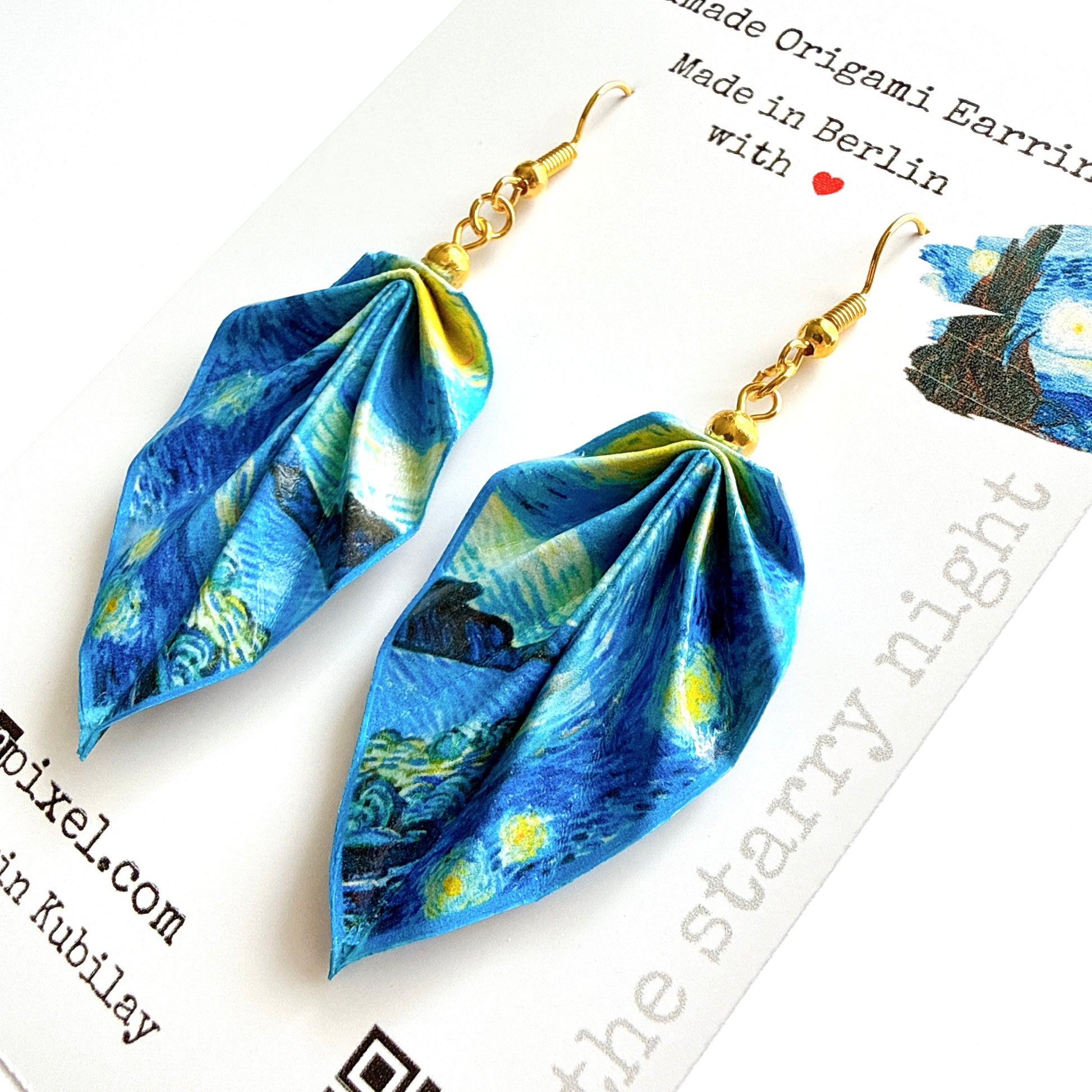 Pair of blue origami earrings with gold hooks on a white background.
