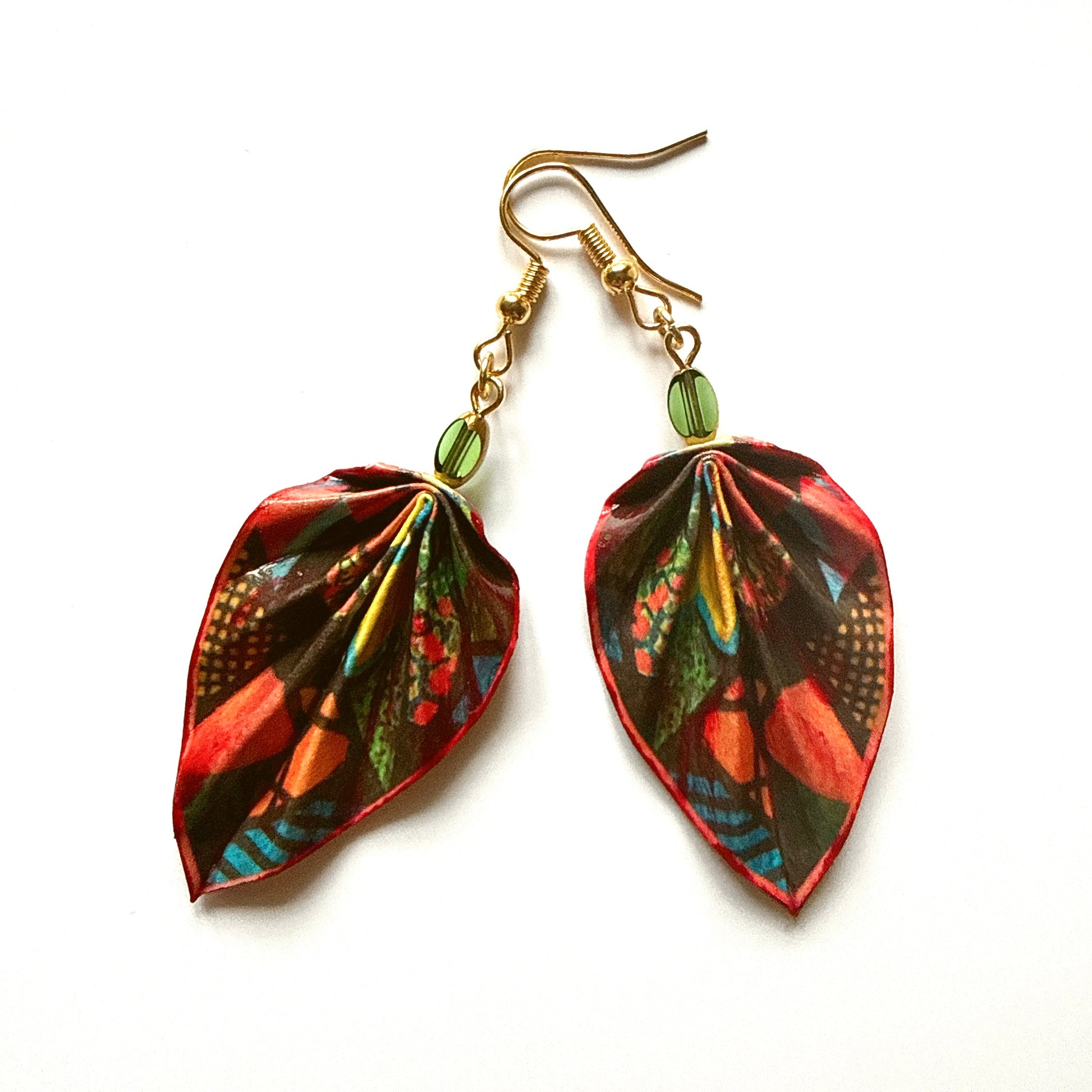 Colorful leaf-shaped earrings with gold hooks on a white background