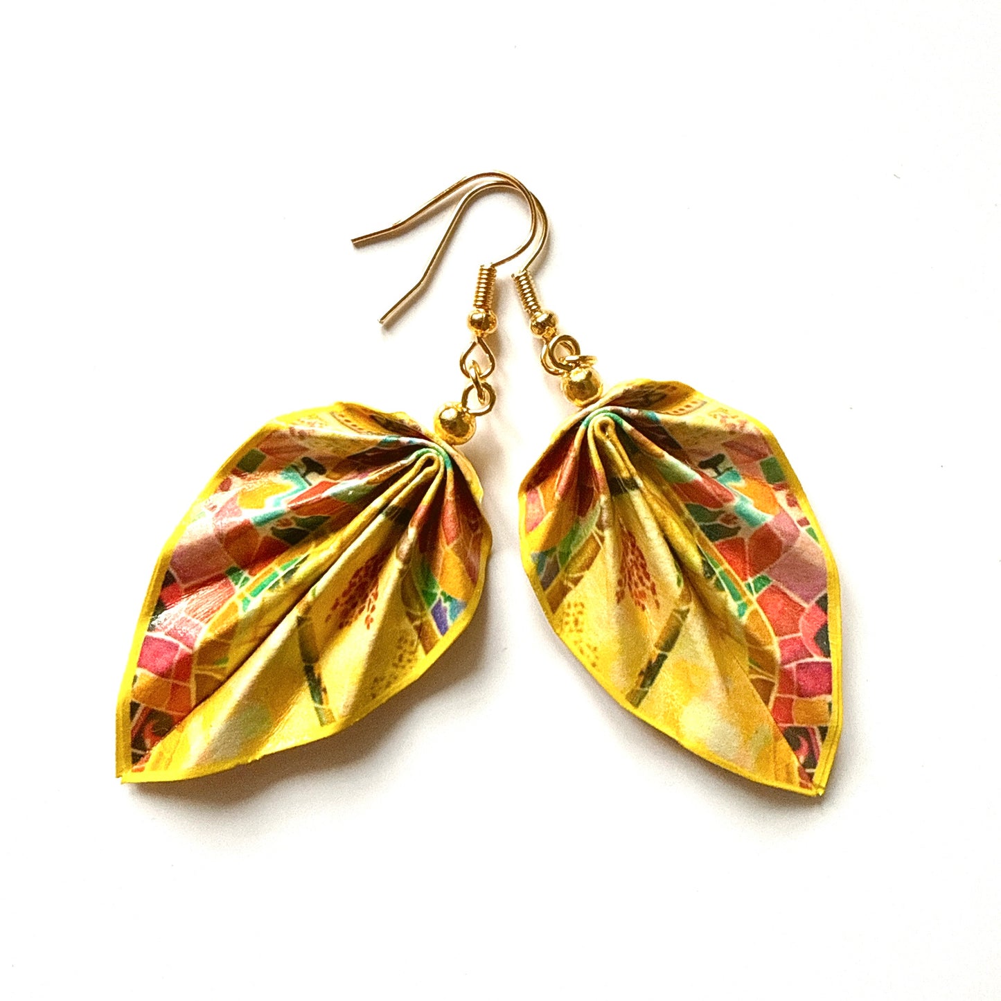 Gold leaf-shaped earrings with colorful patterns on a white background