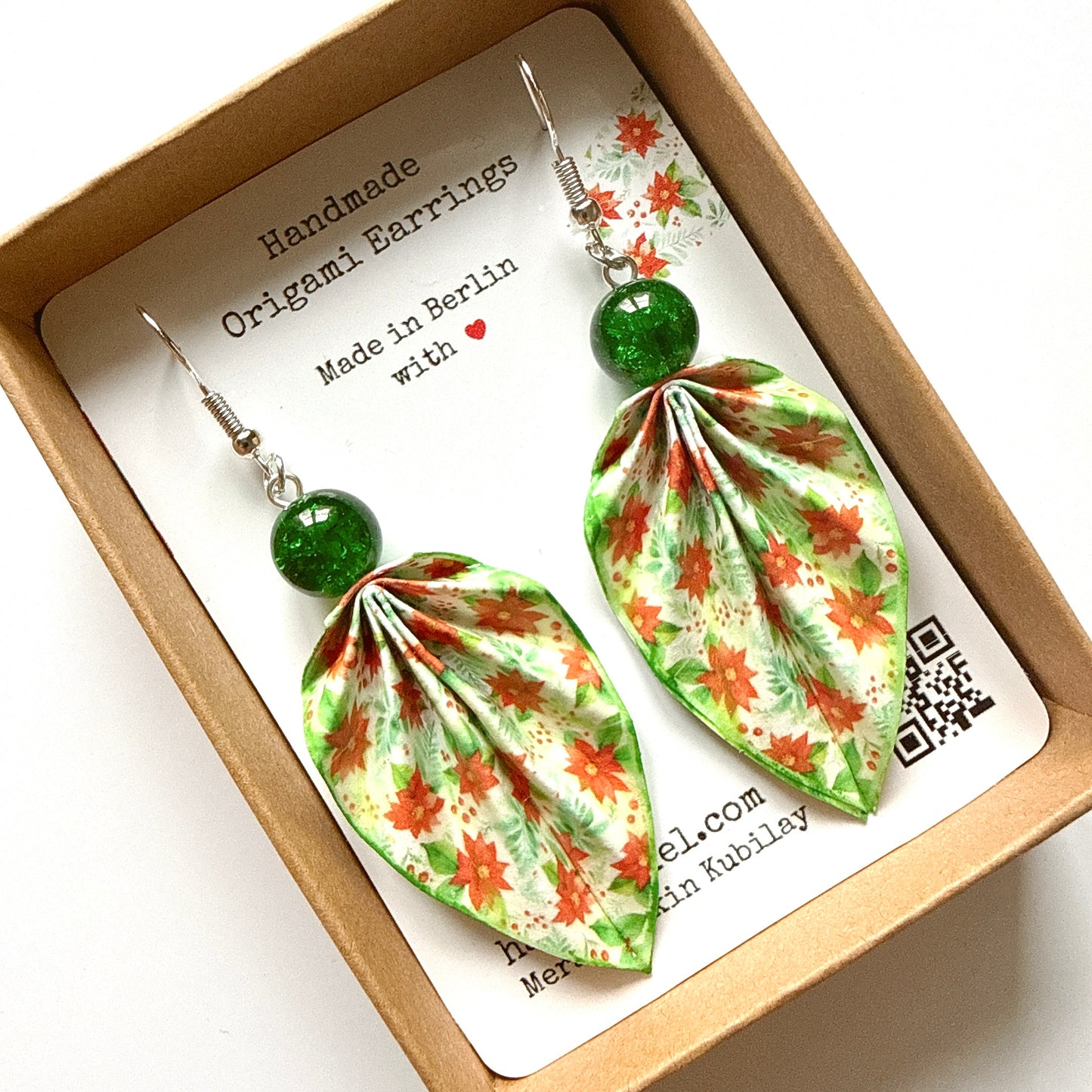 Pair of origami earrings with floral design in a box with a label.