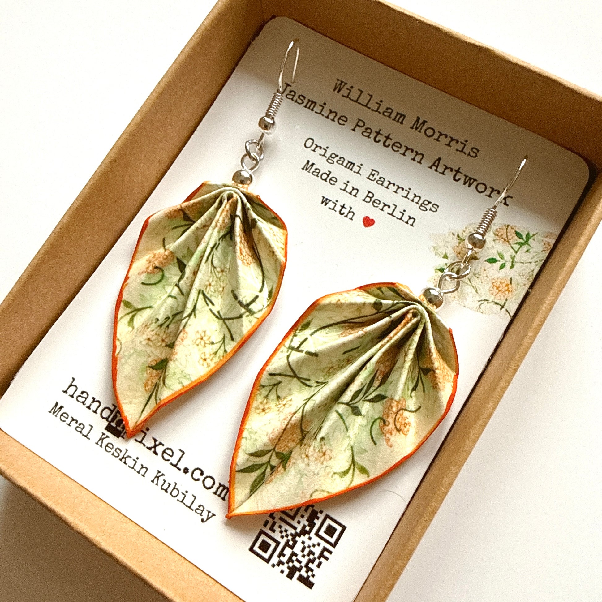 Pair of origami-style earrings with a card detailing the brand and design inspiration.